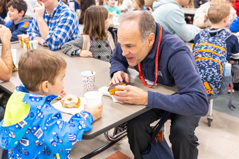 Students and their families enjoy donuts